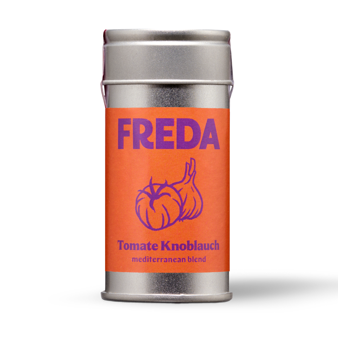 Silberne Gewürzdose mit orangem Etikett, lila Schriftzug "FREDA" und einer Zeichnung von Tomaten und Knoblauch.