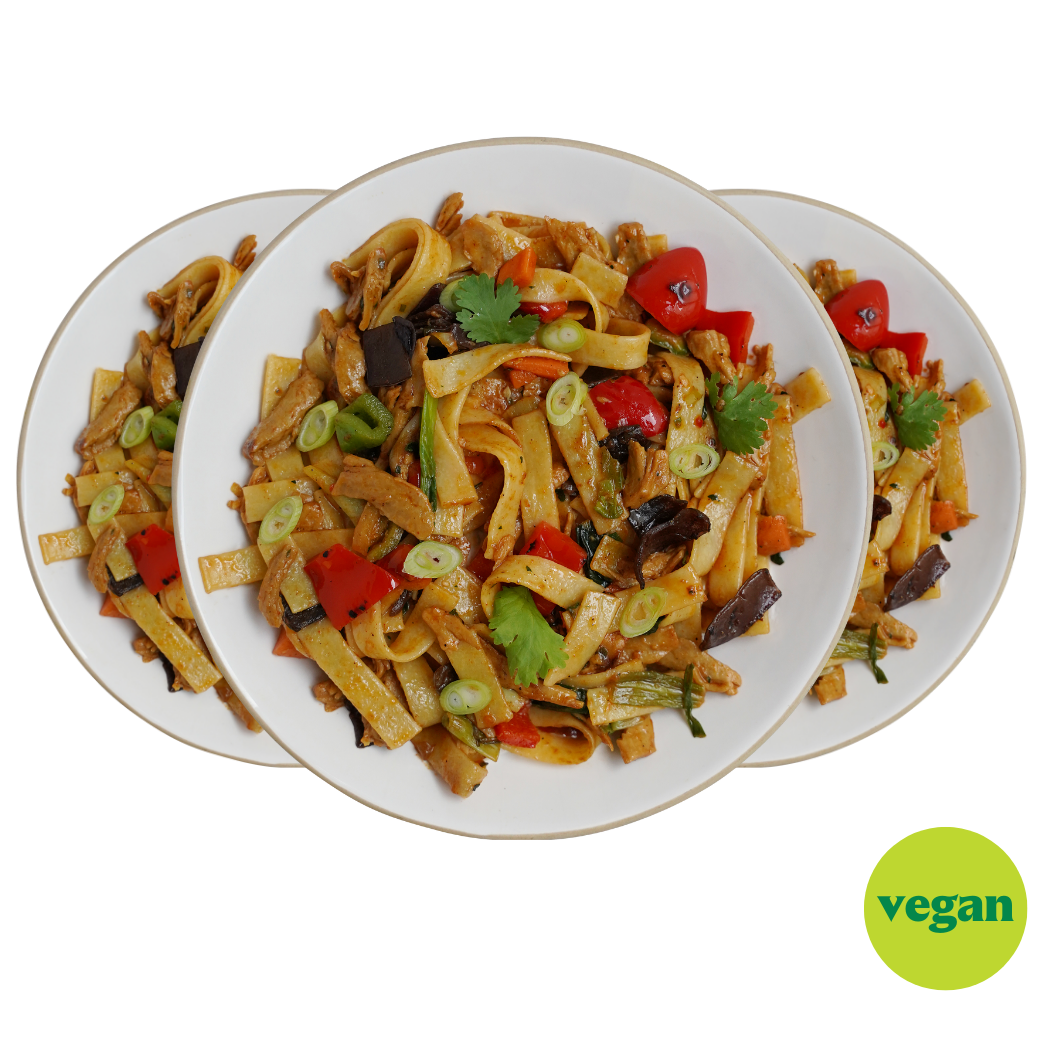 Drei Teller mit buntem veganem Nudelgericht, dekoriert mit Koriander und Frühlingszwiebeln; grünes „vegan“-Label.