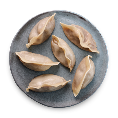 Sechs gedämpfte Dumplings auf einem grauen Teller.