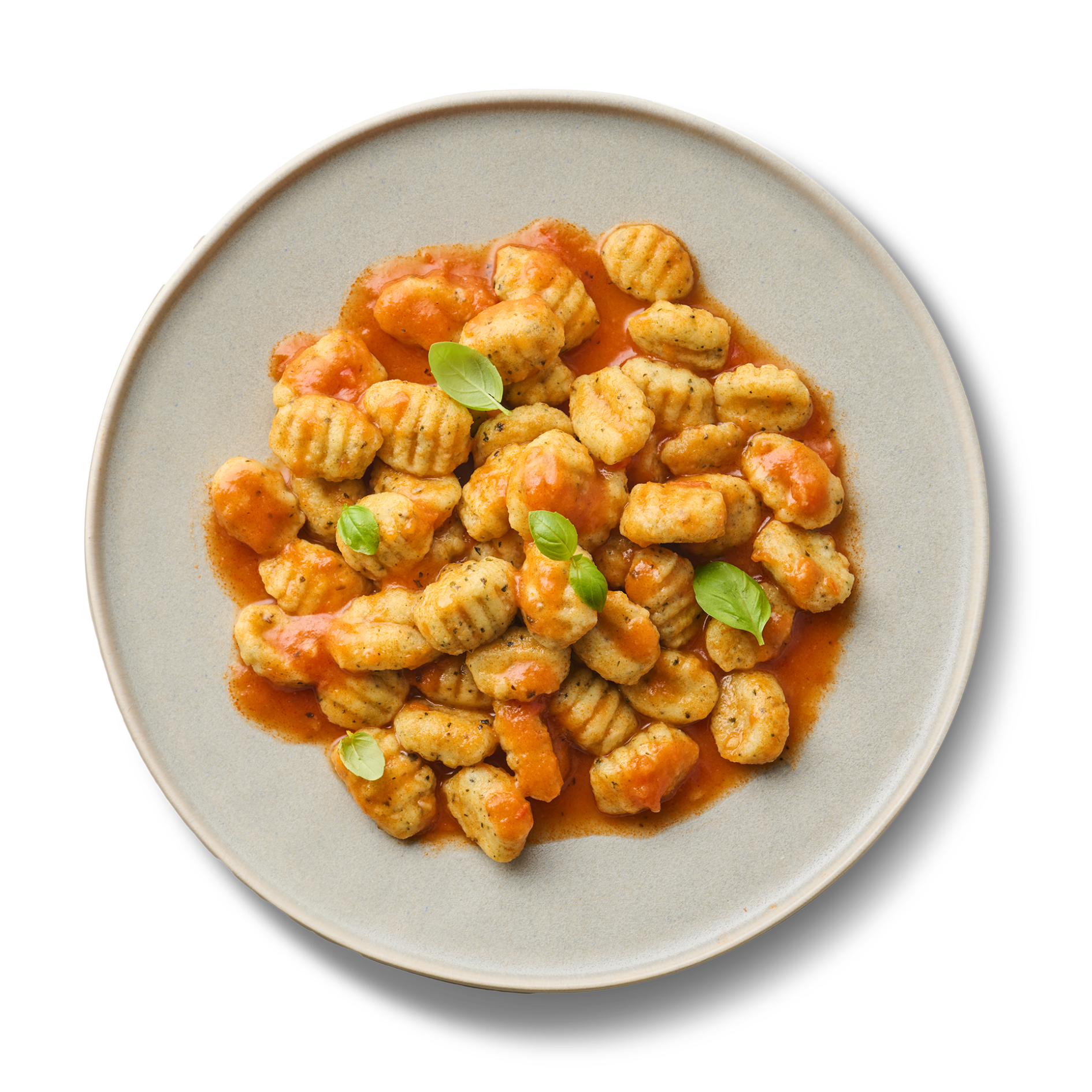 Ein Teller Gnocchi mit Tomatensauce und Basilikumblättern auf schwarzem Hintergrund.