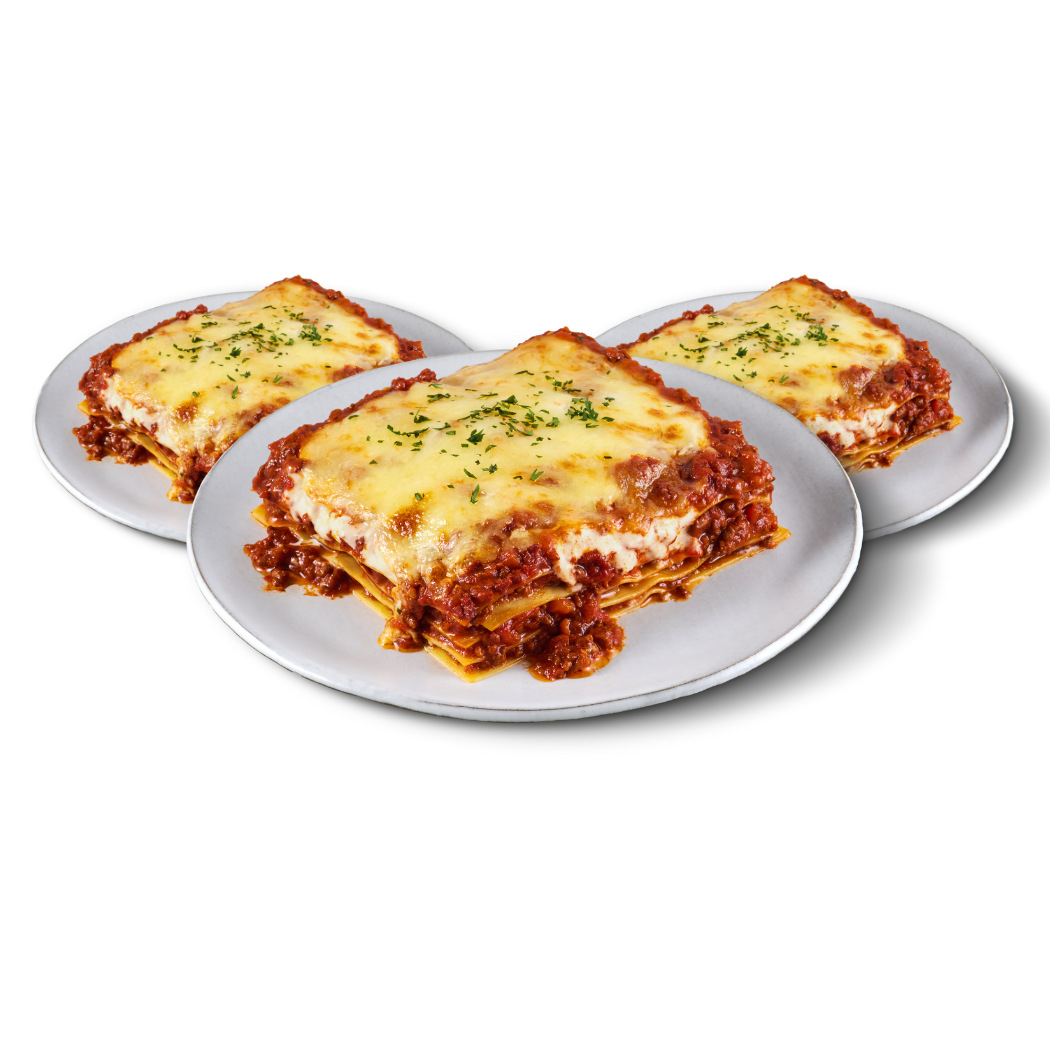 Drei Teller mit großen Stücken Lasagne, garniert mit Kräutern, auf weißen Tellern.
