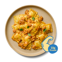 Teller mit Ravioli in Tomatensauce, garniert mit Petersilie. Ein Symbol zeigt "22g Protein" an.
