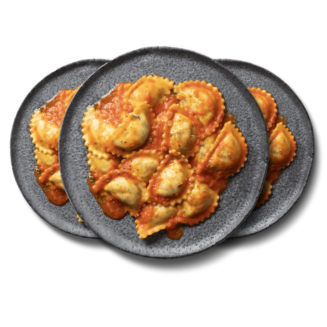 Drei graue Teller mit Ravioli in Tomatensauce, auf schwarzem Hintergrund angeordnet.