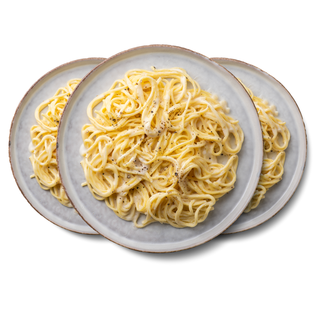 Drei Teller Spaghetti mit cremiger Soße und Pfeffer, aus der Vogelperspektive gesehen.