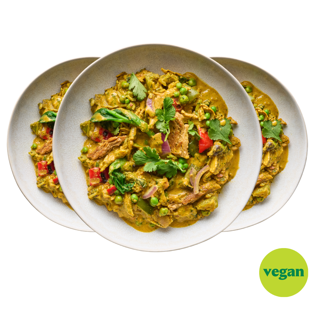 Drei Teller mit veganem Curry, garniert mit Koriander und Erbsen, auf hellem Hintergrund. Ein grünes "vegan"-Symbol.
