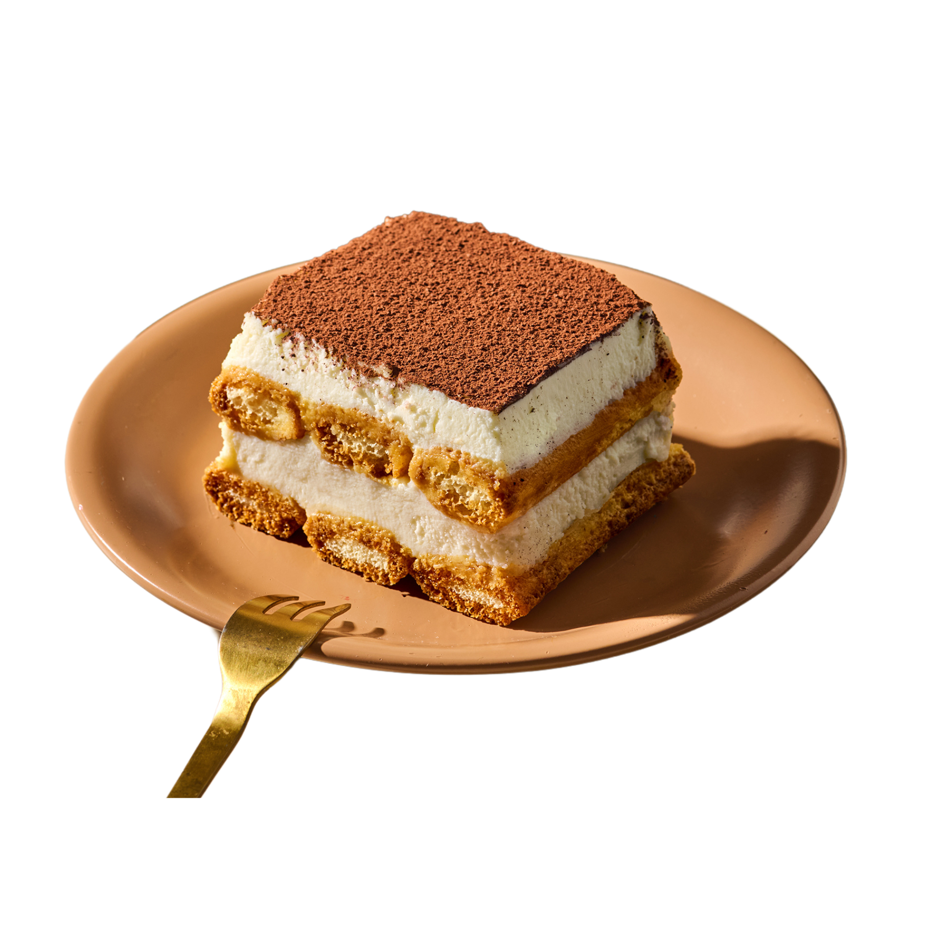 Ein Stück Tiramisu auf einem orangefarbenen Teller mit einer goldenen Gabel daneben.