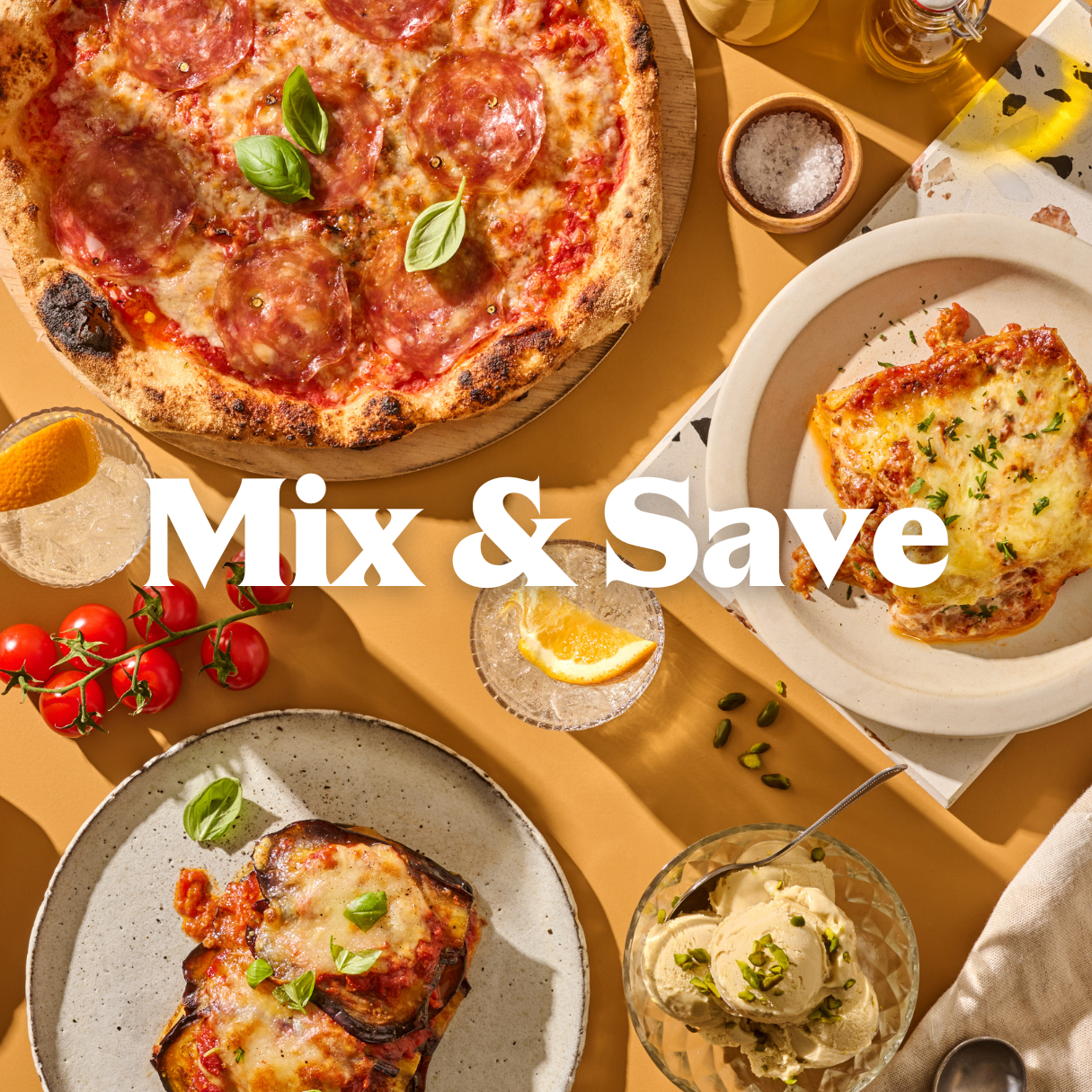 Ein Tisch mit Pizza, Lasagne, Tomaten, zwei Getränken mit Orangenscheiben und Eiscreme. Text: "Mix & Save".