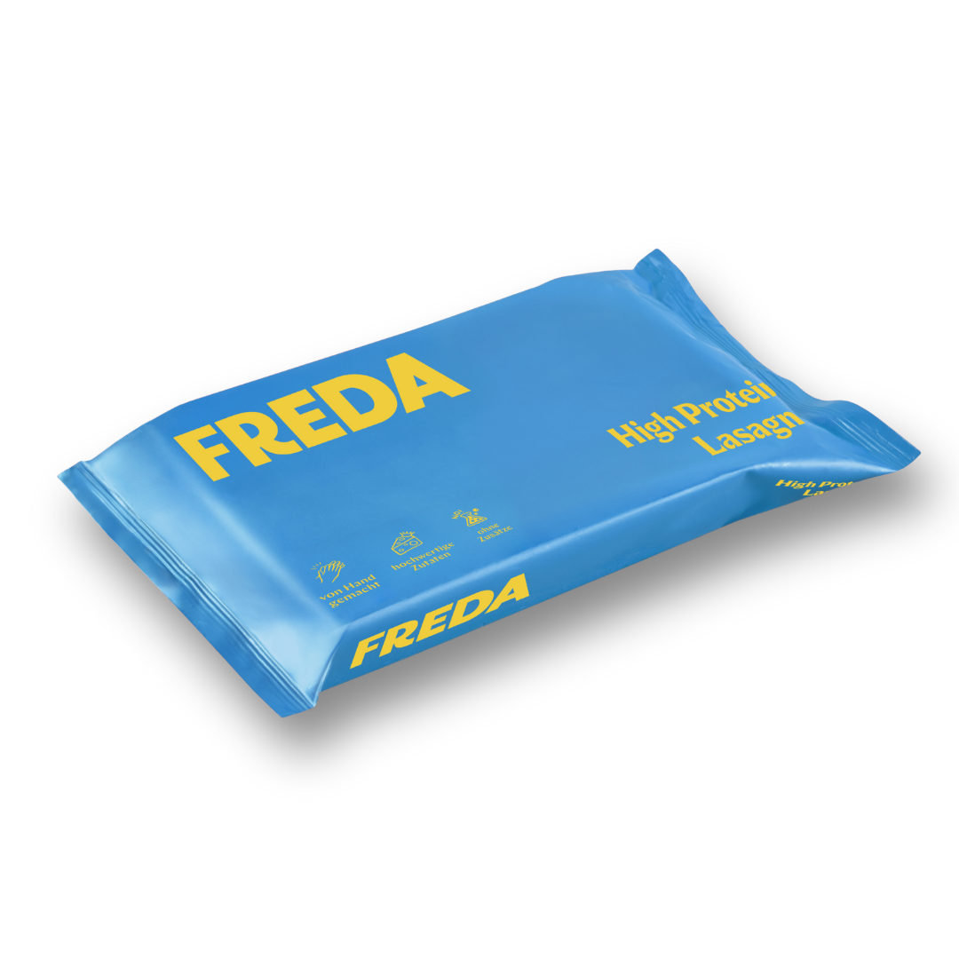 Blaue Verpackung mit gelbem "FREDA"-Logo, beschriftet mit "High Protein Lasagna" und Piktogrammen.